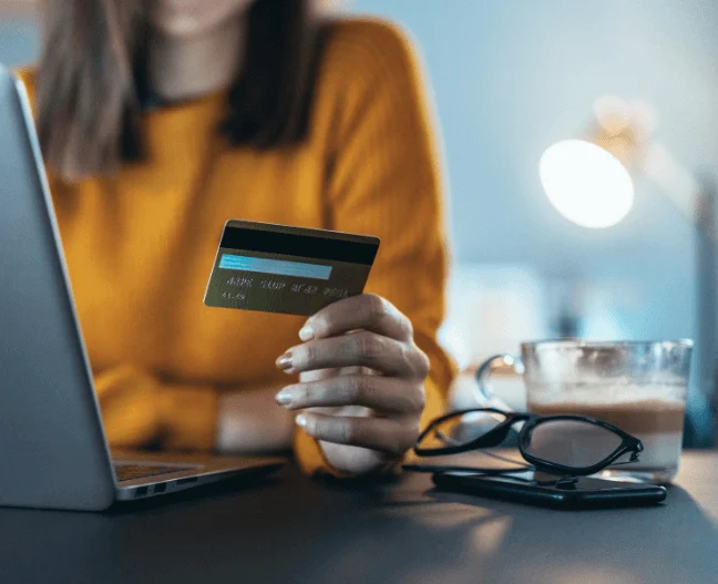 carta di credito fra le mani di un utente che naviga
